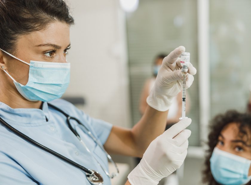 Nurse Holding Coronavirus Vaccine and Syringe