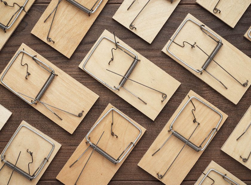 many mousetraps on the wooden background